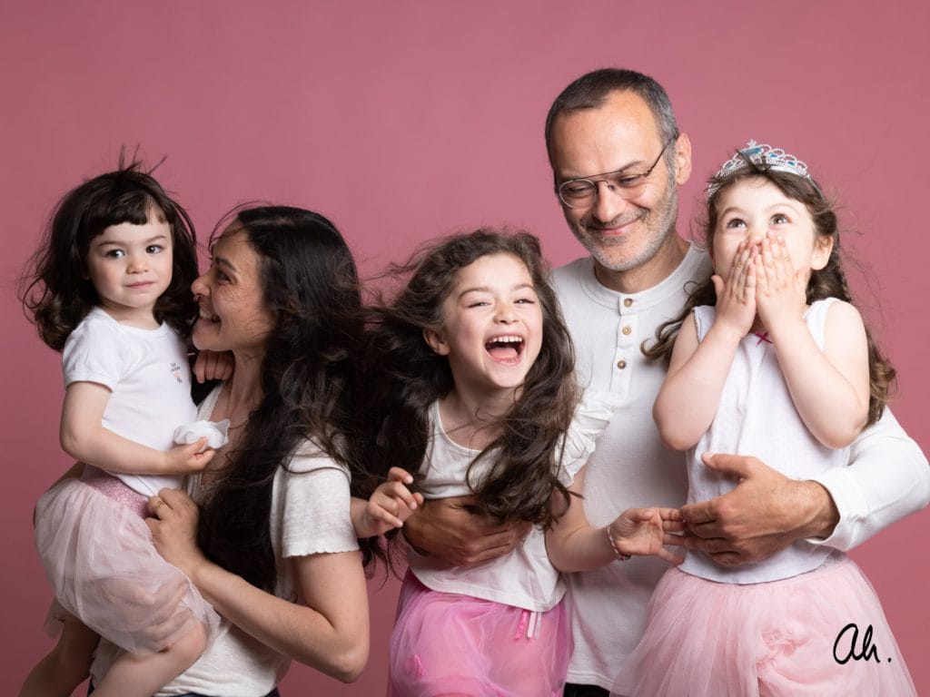 portrait de famille en studio de photographie sur fond rose